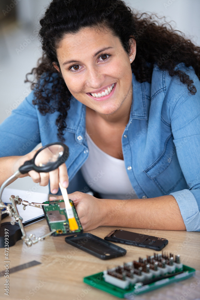 happy female engineer testing circuit board happy female engineer testing circuit board
