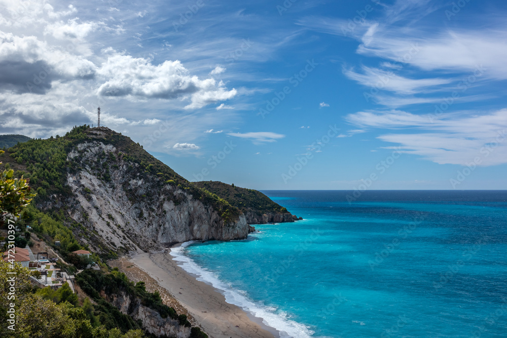 Fototapeta premium Mylos sandy beach with azure vibrant stormy waves on coast of Lefkada island in Greece. Summer nature vacation travel to Ionian Sea