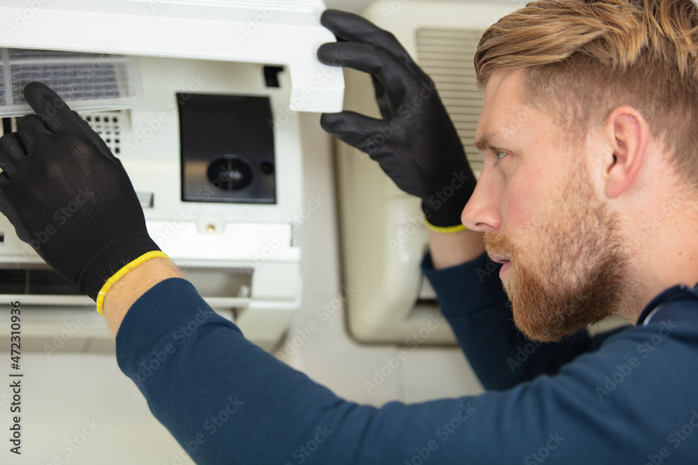professional repair service man installing a clean new air filter professional repair service man installing a clean new air filter