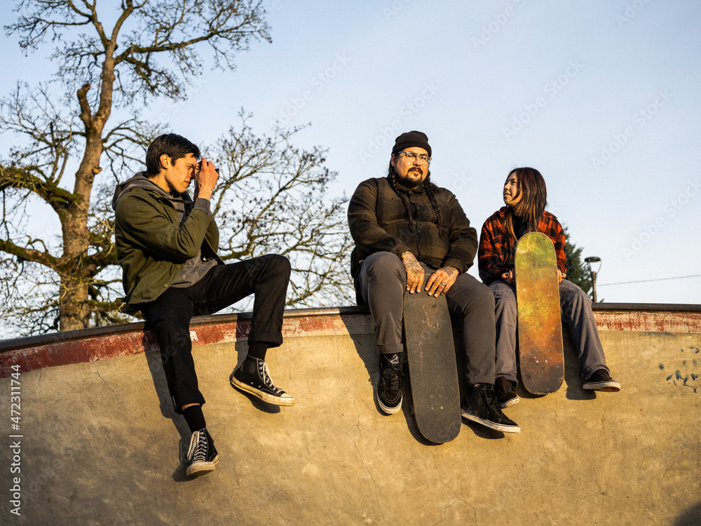 Young Indigenous male photographer, nonbinary skater and father