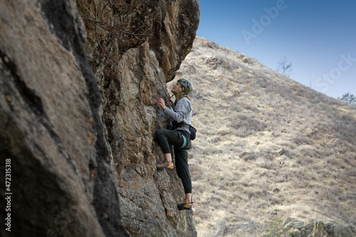 Female rock climber in Colorado takes on a challenging climb. © Ryan
