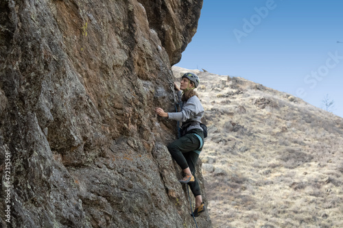 Female rock climber in Colorado takes on a challenging climb.
