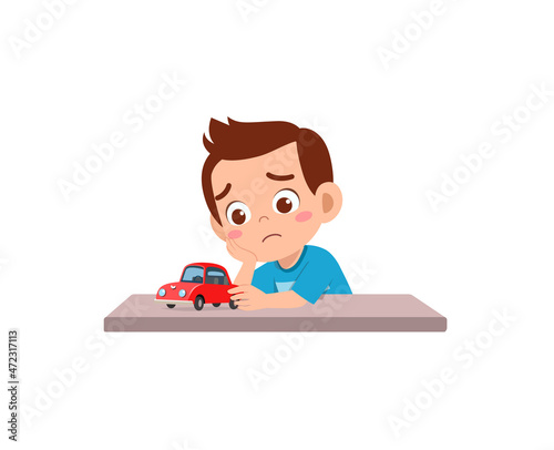 cute boy play toy car alone and feel sad
