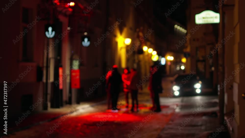 Group of tourists chatting outside a bar with red lights at entrance Group of tourists chatting outside a bar with red lights at entrance