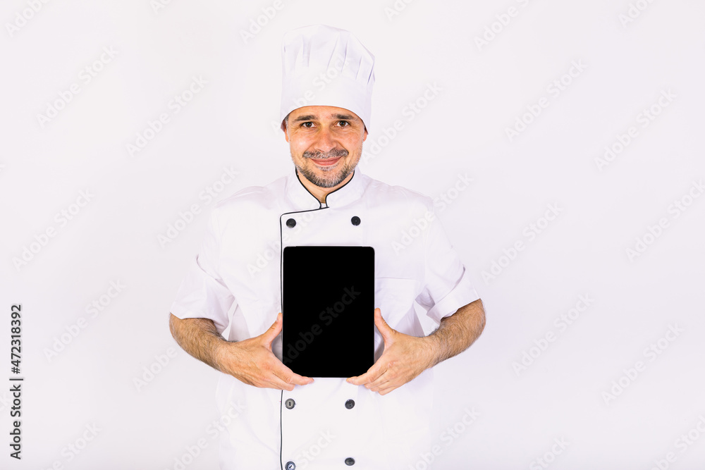 Chef cook wearing kitchen jacket and hat, holding a tablet, showing its screen, on white background Chef cook wearing kitchen jacket and hat, holding a tablet, showing its screen, on white background