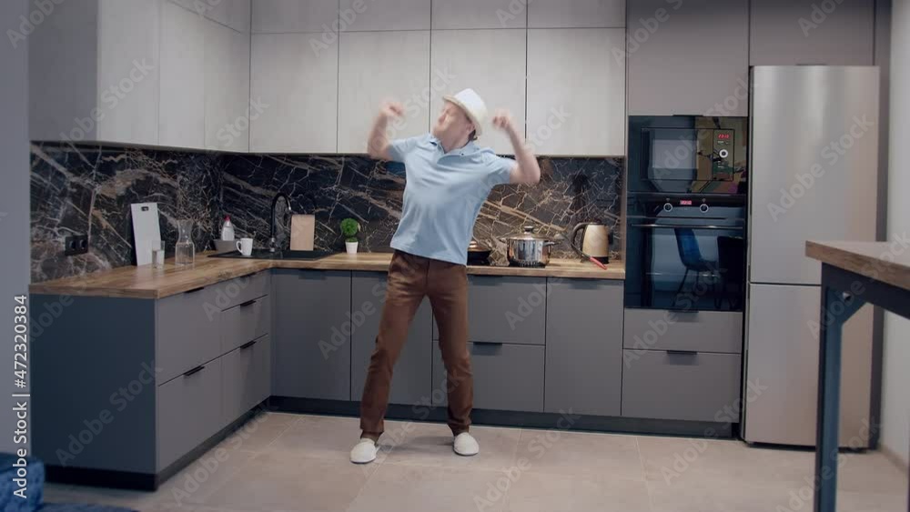 Crazy dance of a young man with a hat in front of the kitchen Crazy dance of a young man with a hat in front of the kitchen