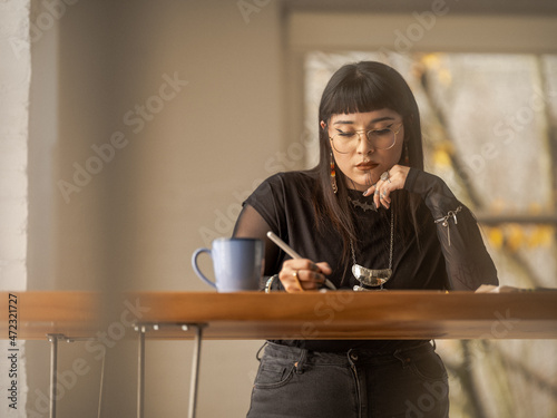 Non binary Indigenous artist drawing indoors photo