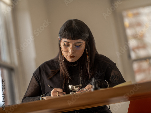 Non binary Indigenous artist drawing indoors photo