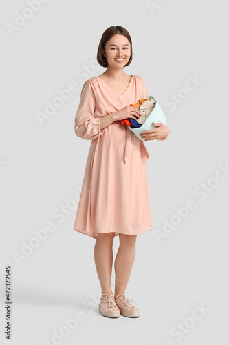 Young pregnant woman holdin...