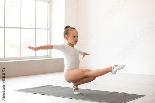 Foto Little girl doing gymnastics in gym