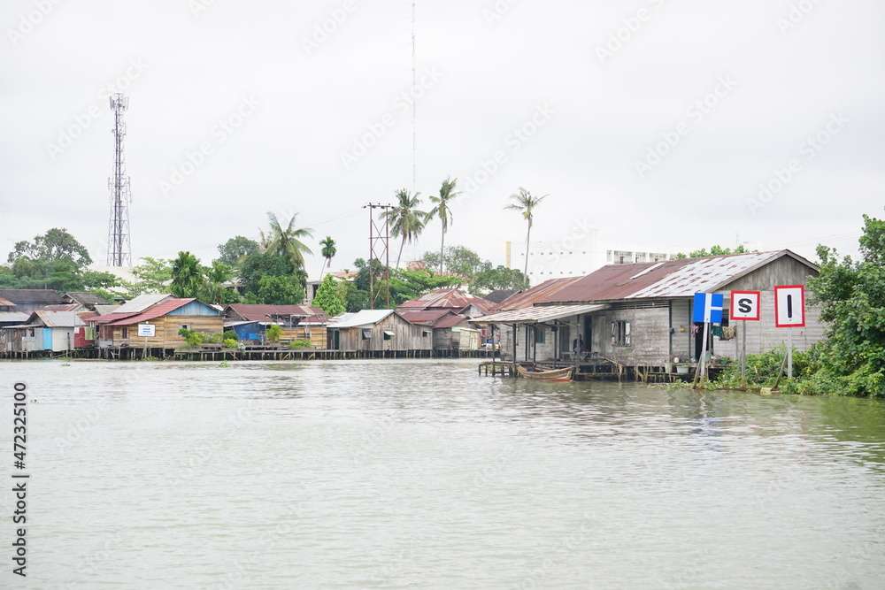 Martapura River with houses and signs on the riverbank