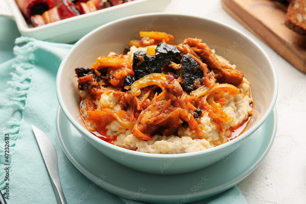 Bowl with delicious oatmeal, beef stew and prunes on table, closeup Bowl with delicious oatmeal, beef stew and prunes on table, closeup