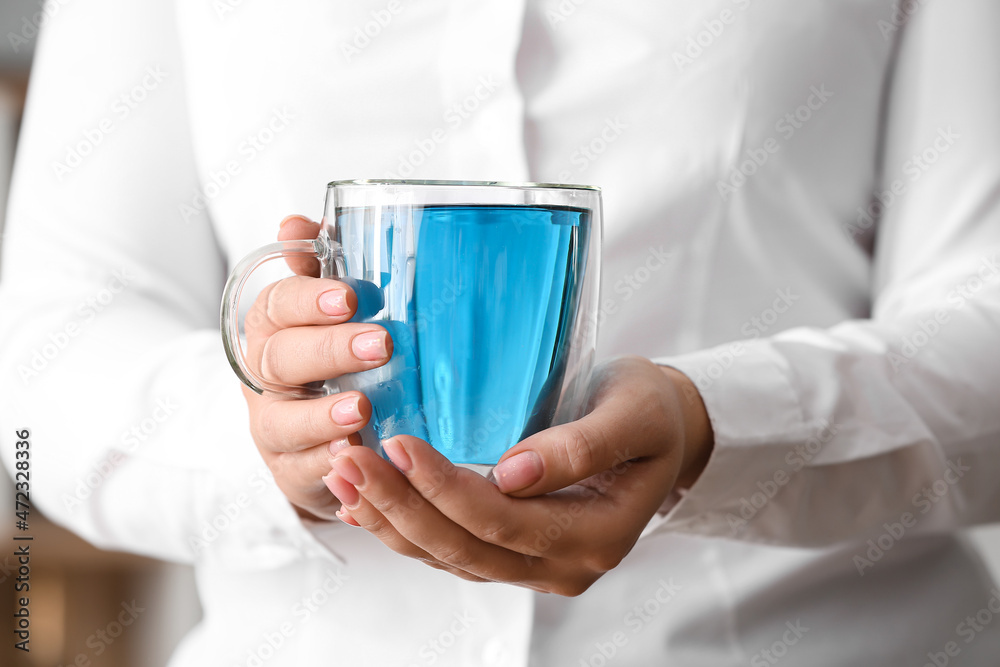 Woman with cup of butterfly pea flower tea, closeup Woman with cup of butterfly pea flower tea, closeup