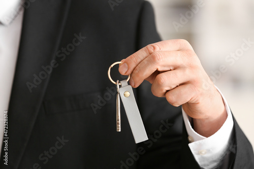 Man holding key on chain, closeup