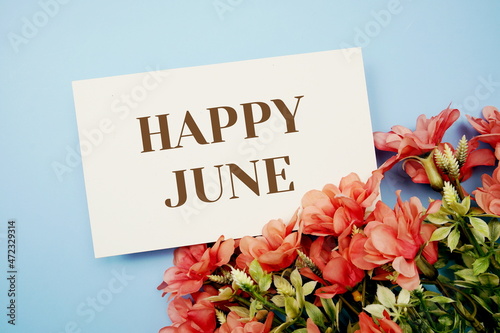 Happy Junetext with flower frame on blue background