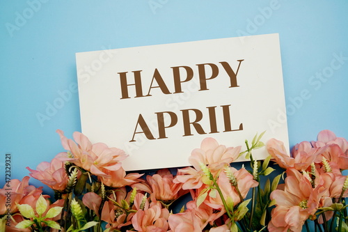Happy Apriltext with flower frame on blue background