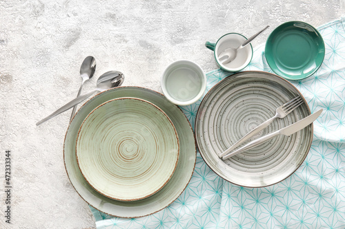 Photos Set of stylish dinnerware on light grunge background
