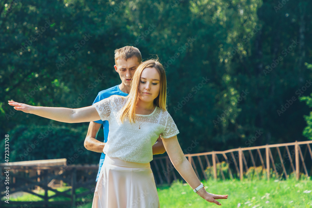 Obraz premium A couple in love walks in a summer park by the lake.A man supports his woman.