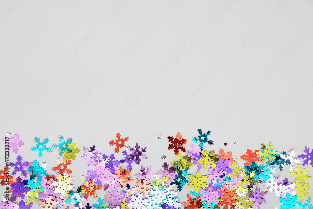 Colorful confetti in shape of snowflakes on white background