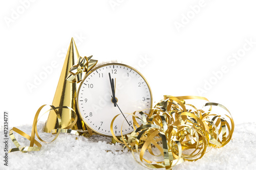 Alarm clock, party hat and serpentine on snow against white background