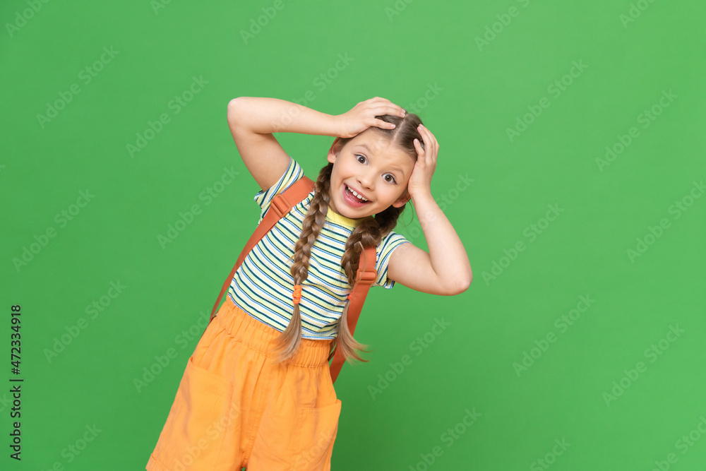 A little girl with a school bag behind her back is holding her head.