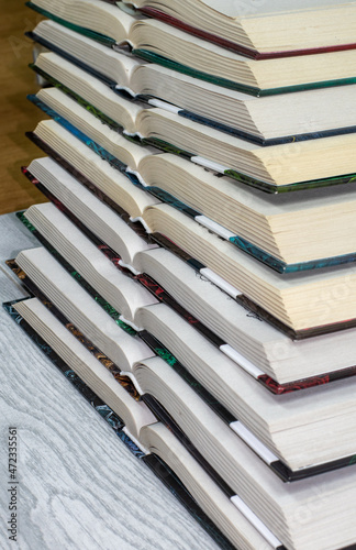 open hardcover books are stacked vertically on top of each other. The concept of loving books  reading books