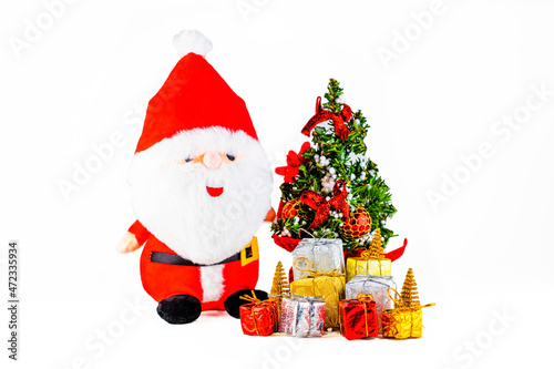 Christmas Concept of generic soft toy of Santa Clause with Christmas tree and gifts on white background