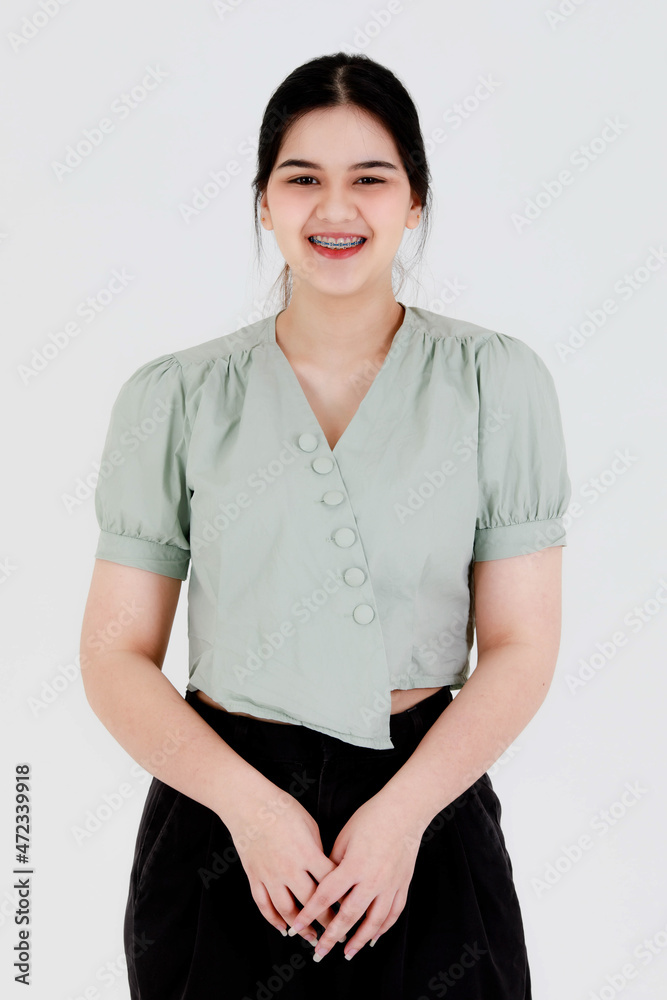 Portrait close up studio head shot of Asian young female ponytail hairstyle teenager model wearing dental care braces teeth and casual outfit standing smiling look at camera on white background Stock Photo | Portrait close up studio head shot of Asian young female ponytail hairstyle teenager model wearing dental care braces teeth and casual outfit standing smiling look at camera on white background Stock Photo |