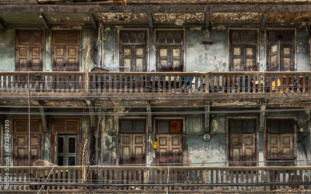 External of old building with wooden windows and wooden door on balconies was left to deteriorate over time, Chinese Architecture style, Old house, No focus, specifically.