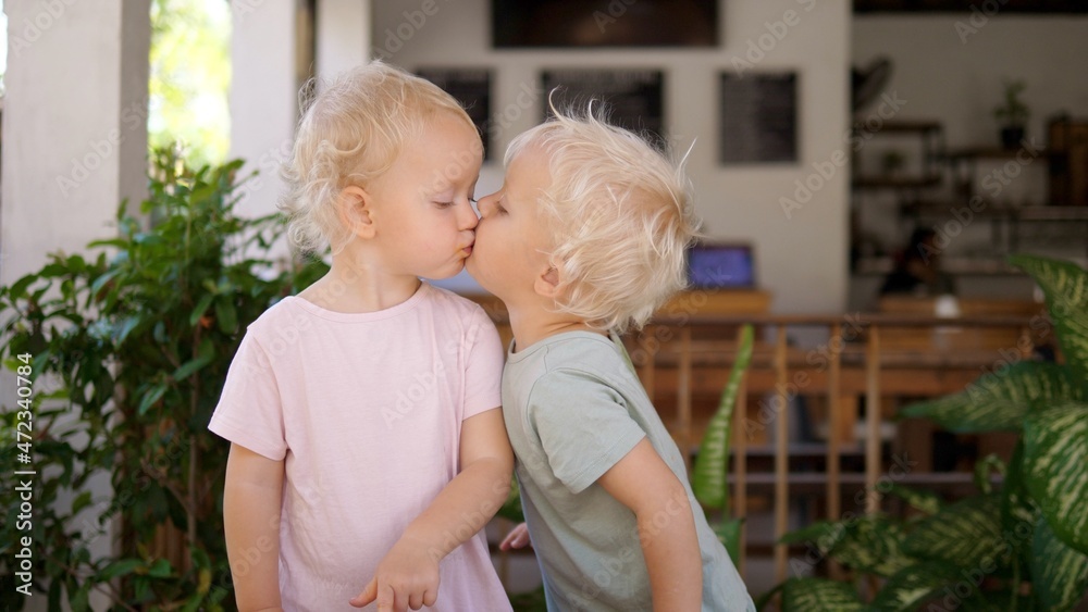 Cute small sisters kissing and eating ice cream Cute small sisters kissing and eating ice cream