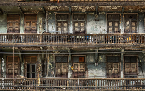 External of old building with wooden windows and wooden door on balconies was left to deteriorate over time, Chinese Architecture style, Old house, No focus, specifically.