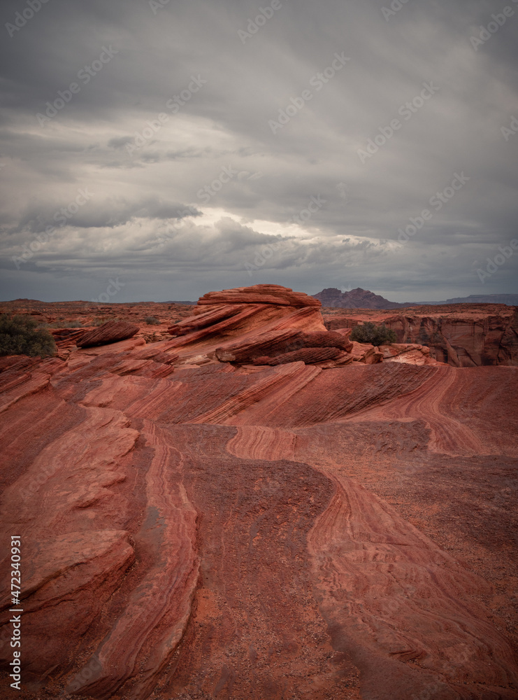 View of Wavy Stones Made with Red Rock, storm clouds in the sky, Arches National Park, Utah, USA