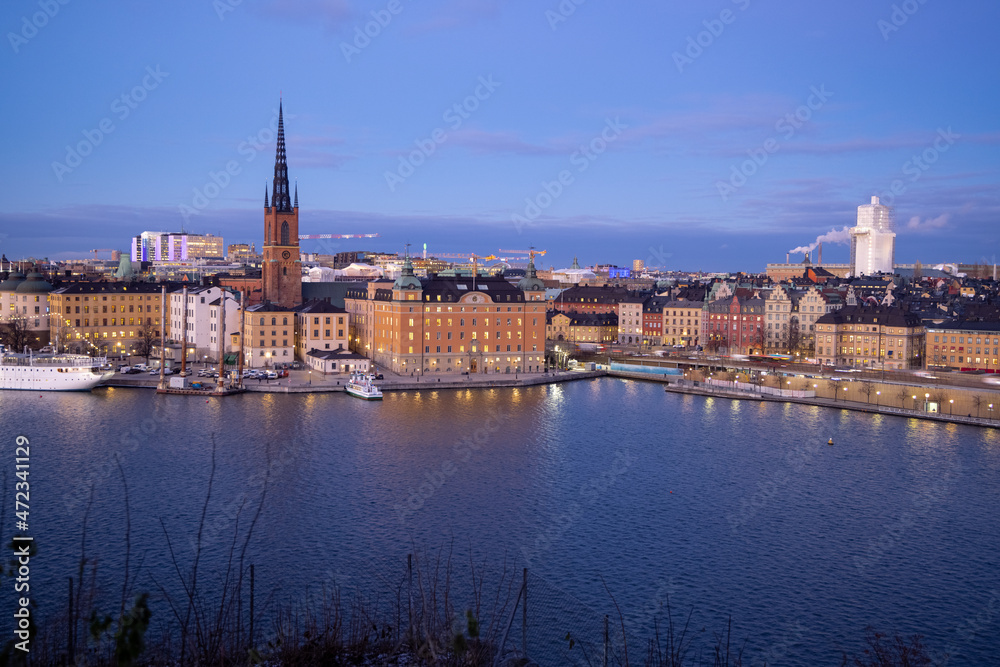 Beautiful panorama of Stockholm at night with sea, buildings, boats and night city lights. Capital of Sweden photographed from the hill. 