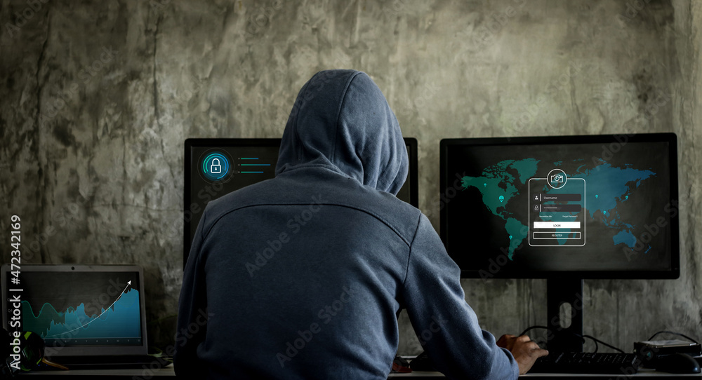Hacker, hacker hacks network, hacker on a dark background. Dangerous Hooded Hacker Breaks into Government Data Servers Hacker, hacker hacks network, hacker on a dark background. Dangerous Hooded Hacker Breaks into Government Data Servers