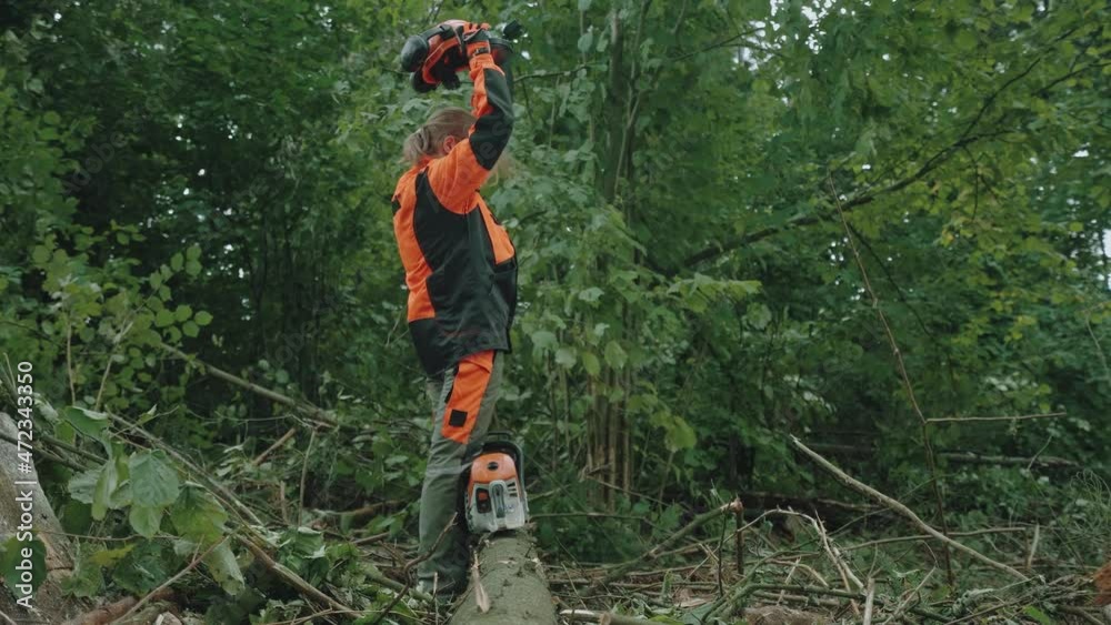 Portrait of a woman logger standing in the forest, female specialist in protective gear puts off helmet after hard work, 4k slow motion. Portrait of a woman logger standing in the forest, female specialist in protective gear puts off helmet after hard work, 4k slow motion.
