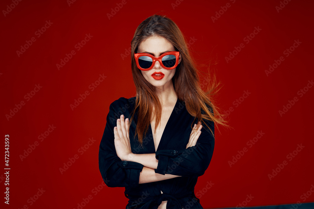 pretty woman wearing sunglasses fashion posing hairstyle red background