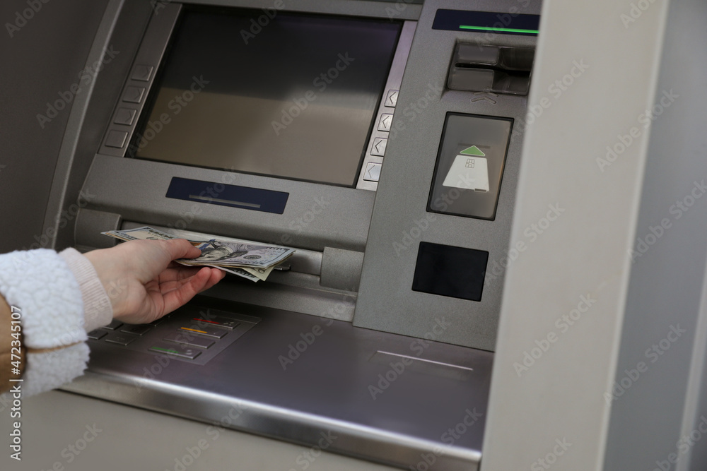 Woman using cash machine for money withdrawal, closeup Woman using cash machine for money withdrawal, closeup