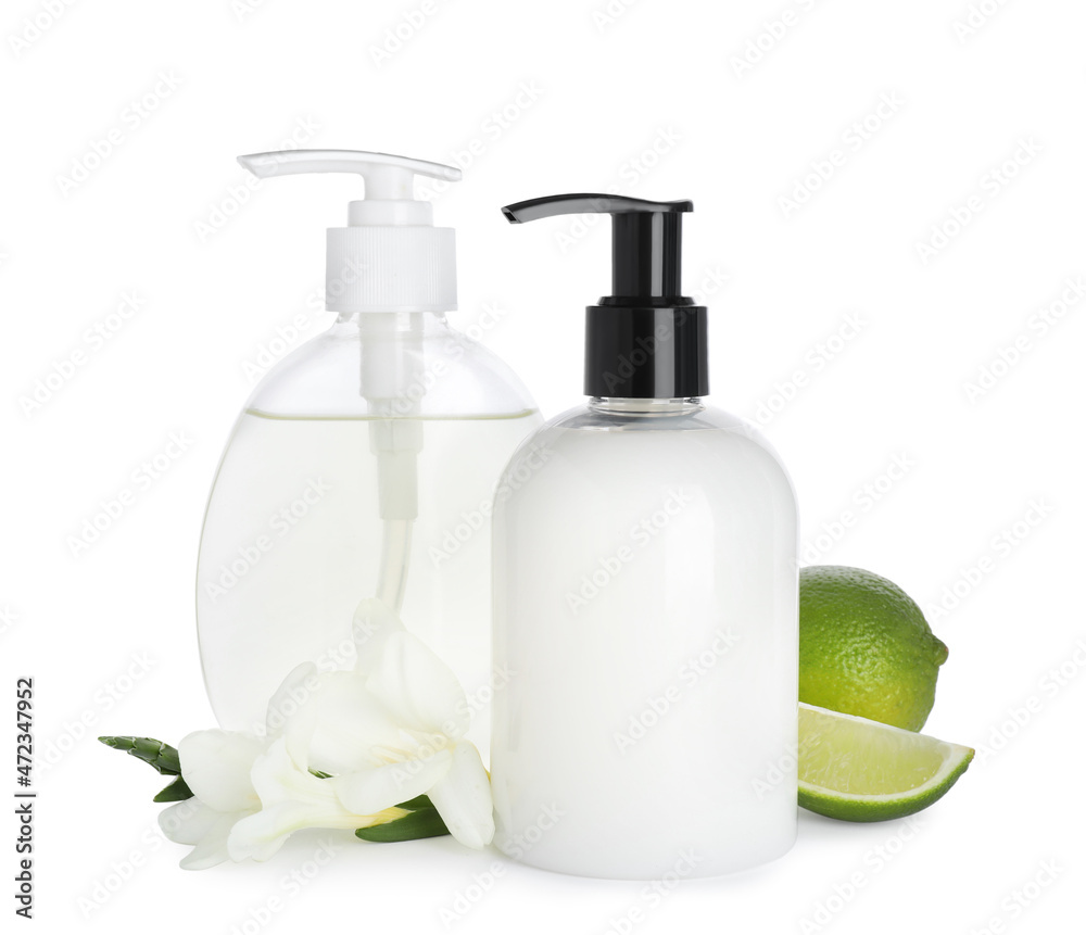 Dispensers with liquid soap, freesia flowers and limes on white background