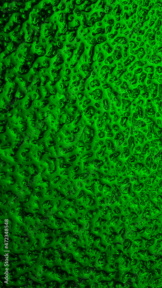 Bright green winter background. The surface of ice frozen on the window glass. An abstract pattern with a metallic sheen, like streams of mercury. Rich vivid mobile phone wallpaper. Close-up Bright green winter background. The surface of ice frozen on the window glass. An abstract pattern with a metallic sheen, like streams of mercury. Rich vivid mobile phone wallpaper. Close-up