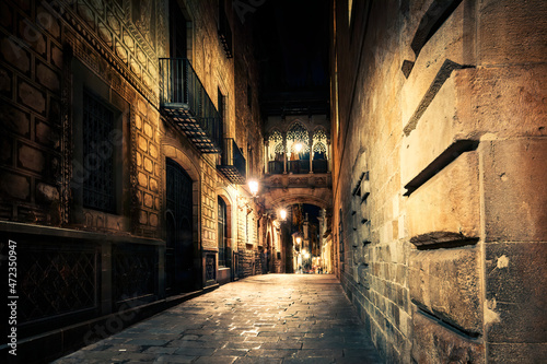 Gothic quarter at night. Empty alleyways in Barcelona. Bridge between buildings in Barri Gothic quarter of Barcelona, Catalonia, Spain