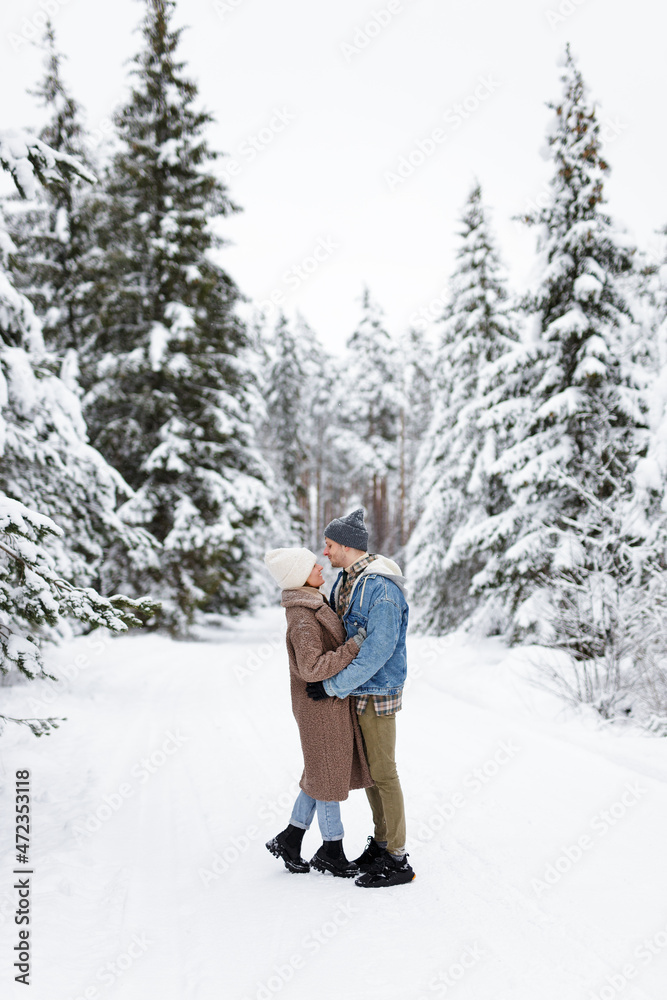 young couple standing and enjoying winter in forest