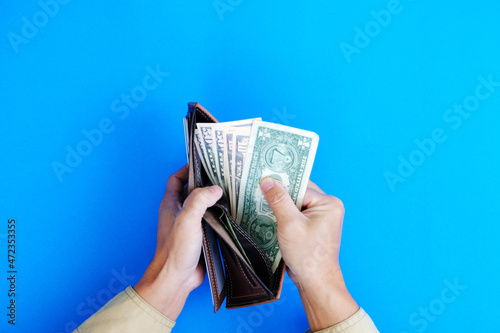 Finance and banking are represented by a hand holding a bank note with the concept of money on a blue backdrop.