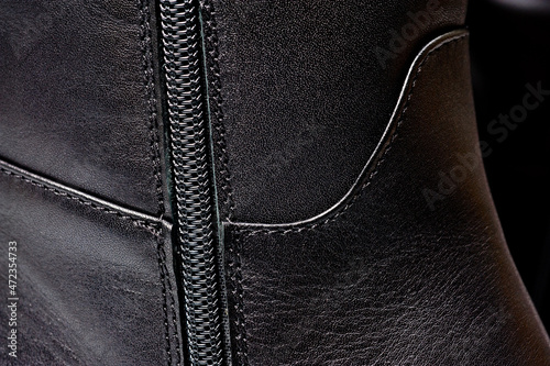 Black leather women’s boots fastened with a zipper. Background for shoes.