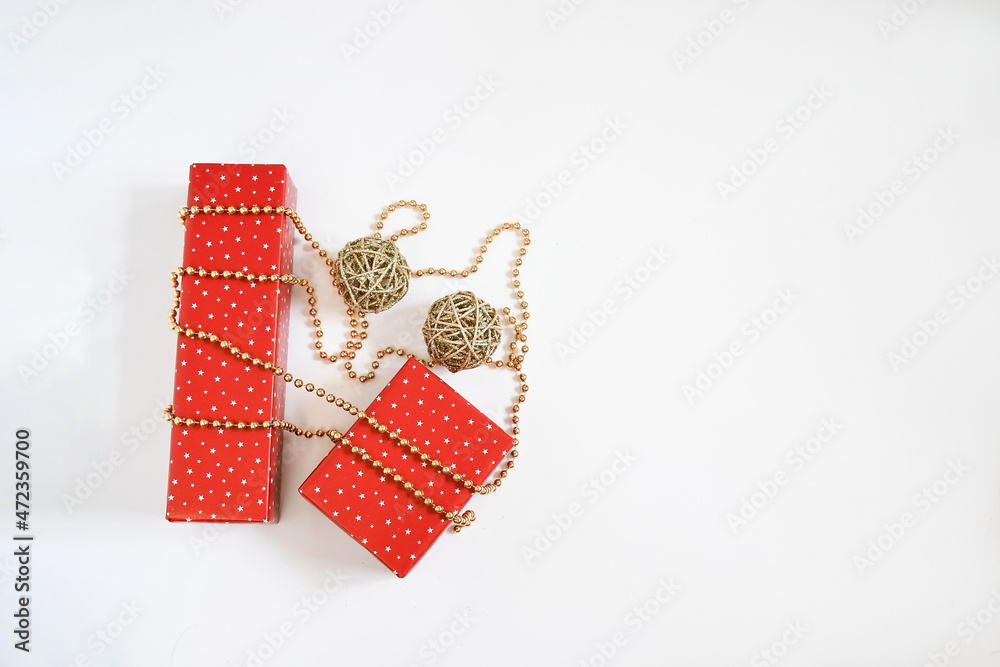 Obraz premium Christmas gift boxes wrap with red star paper on golden necklace on white background with space for text. Handmade objects , Christmas holiday concept.