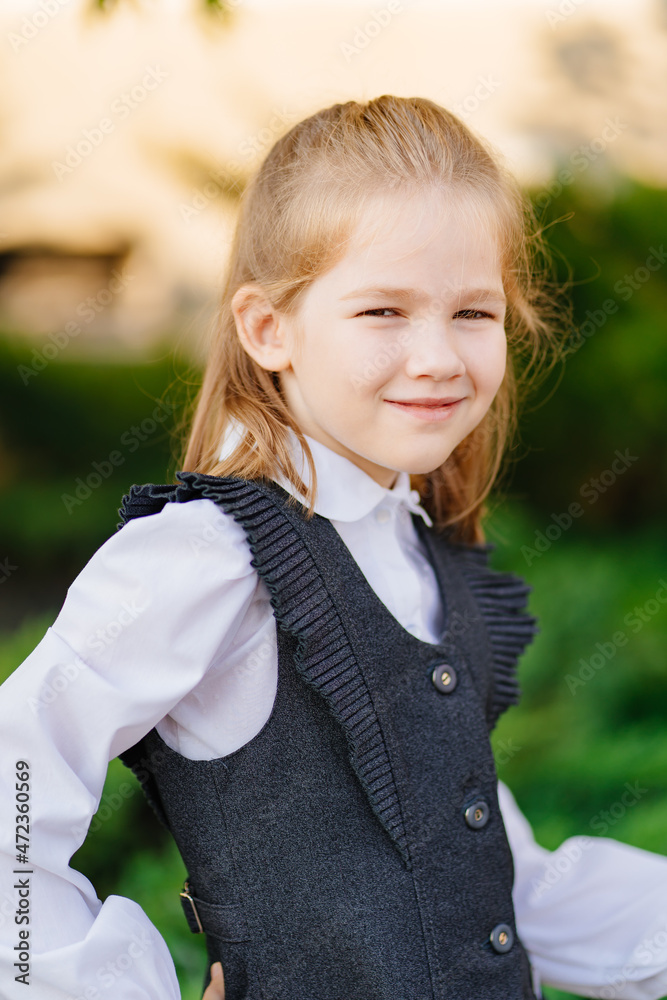 a cute girl in a gray school uniform. sale of clothes for schoolchildren.
