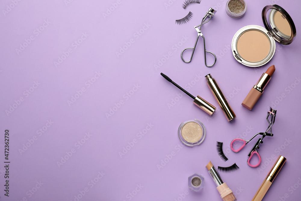 Eyelash curlers and makeup products on violet background, flat lay. Space for text