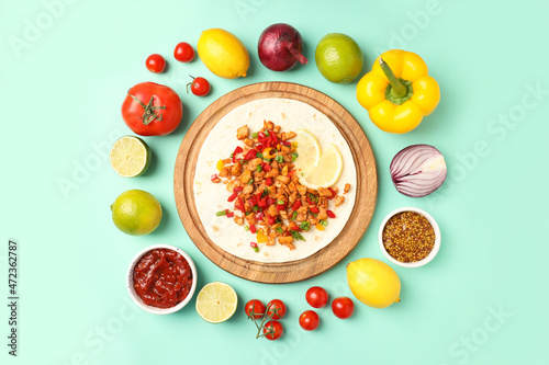 Concept of tasty food with taco on mint background