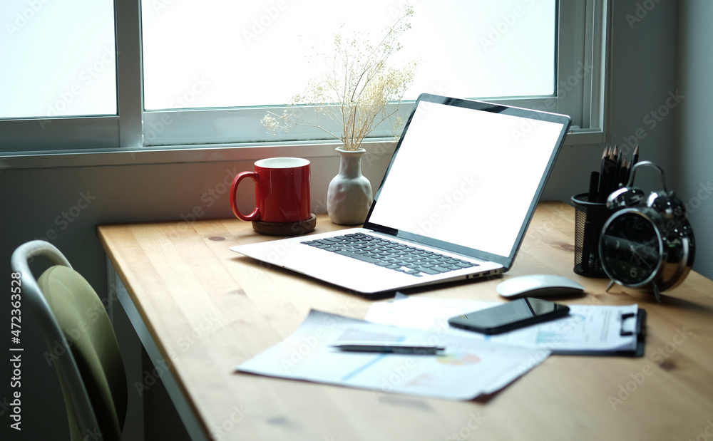 Laptop computer with blank screen, coffee cup, clipboard and pencil holder on wooden desk. Laptop computer with blank screen, coffee cup, clipboard and pencil holder on wooden desk.