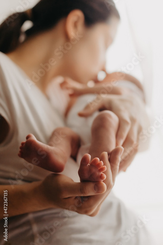 legs of a newborn baby in parental hands