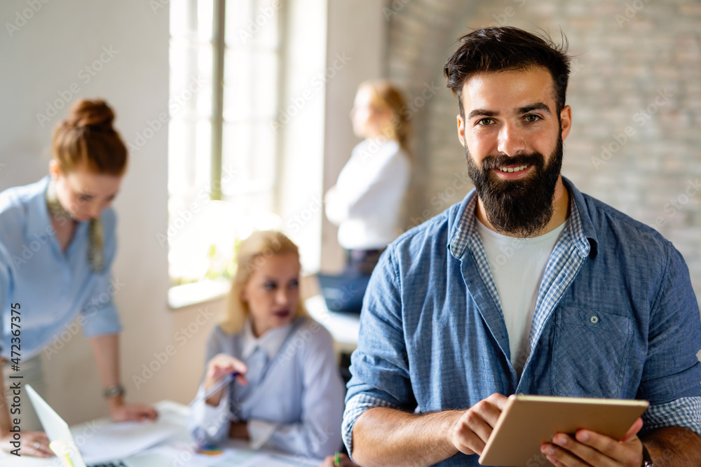 Portrait of happy successful business people working on tablet in office. Business teamwork concept Portrait of happy successful business people working on tablet in office. Business teamwork concept